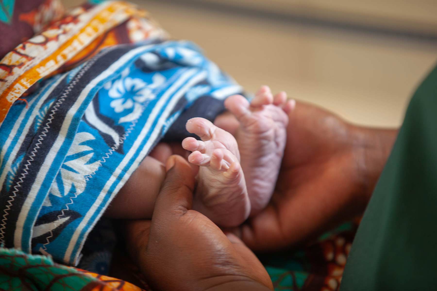 A medical worker checking the feet of a newborn baby