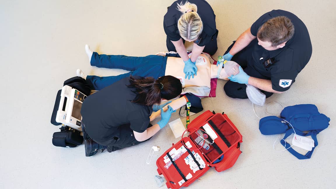 Three healthcare personnel training with a realistic resuscitation manikin