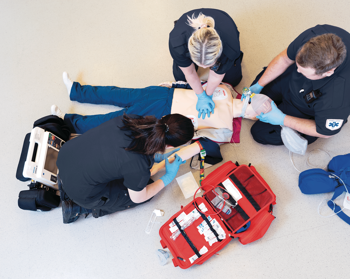 Three healthcare personnel training with a realistic resuscitation manikin