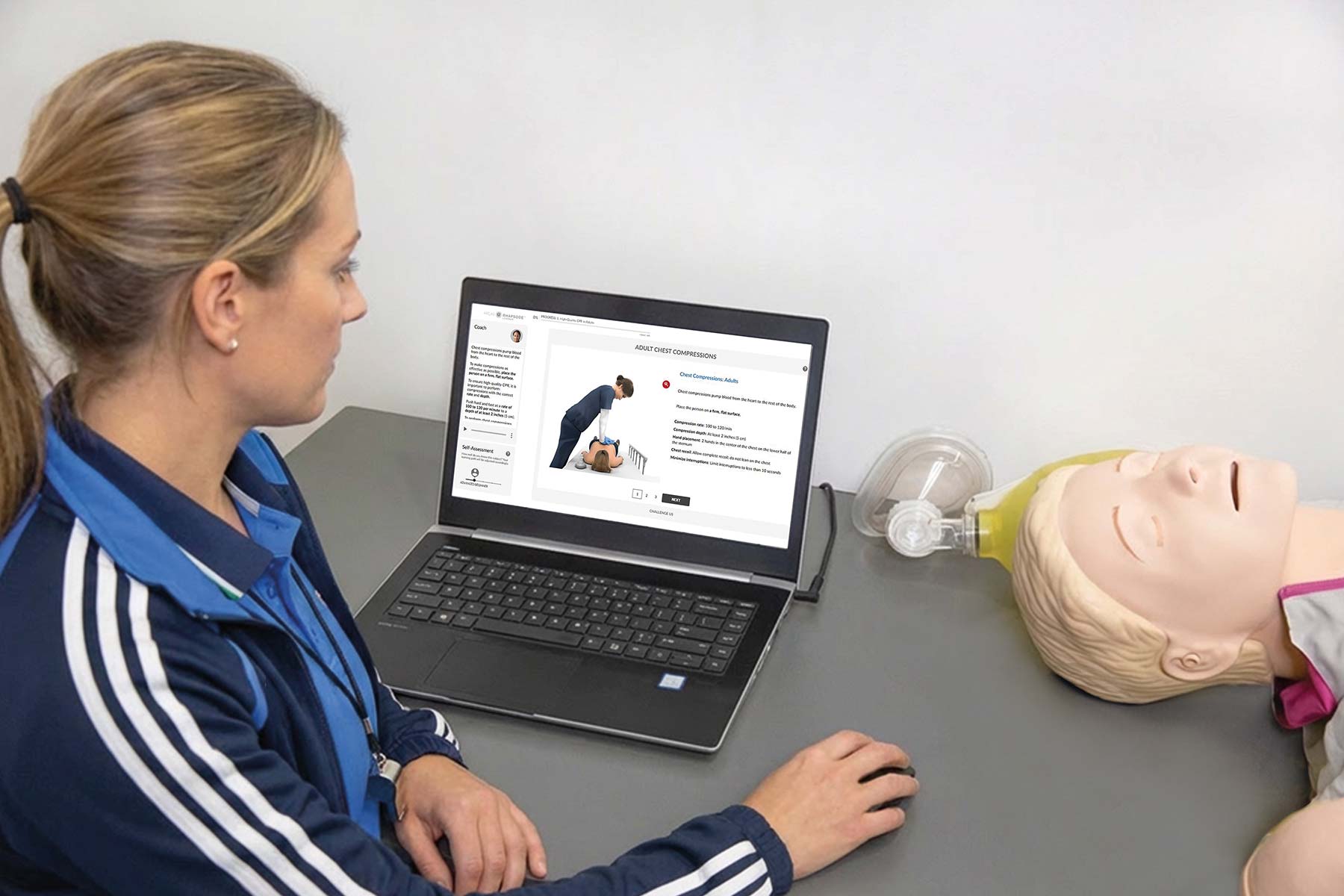 athletic coach performing heartcode on a laptop with manikin