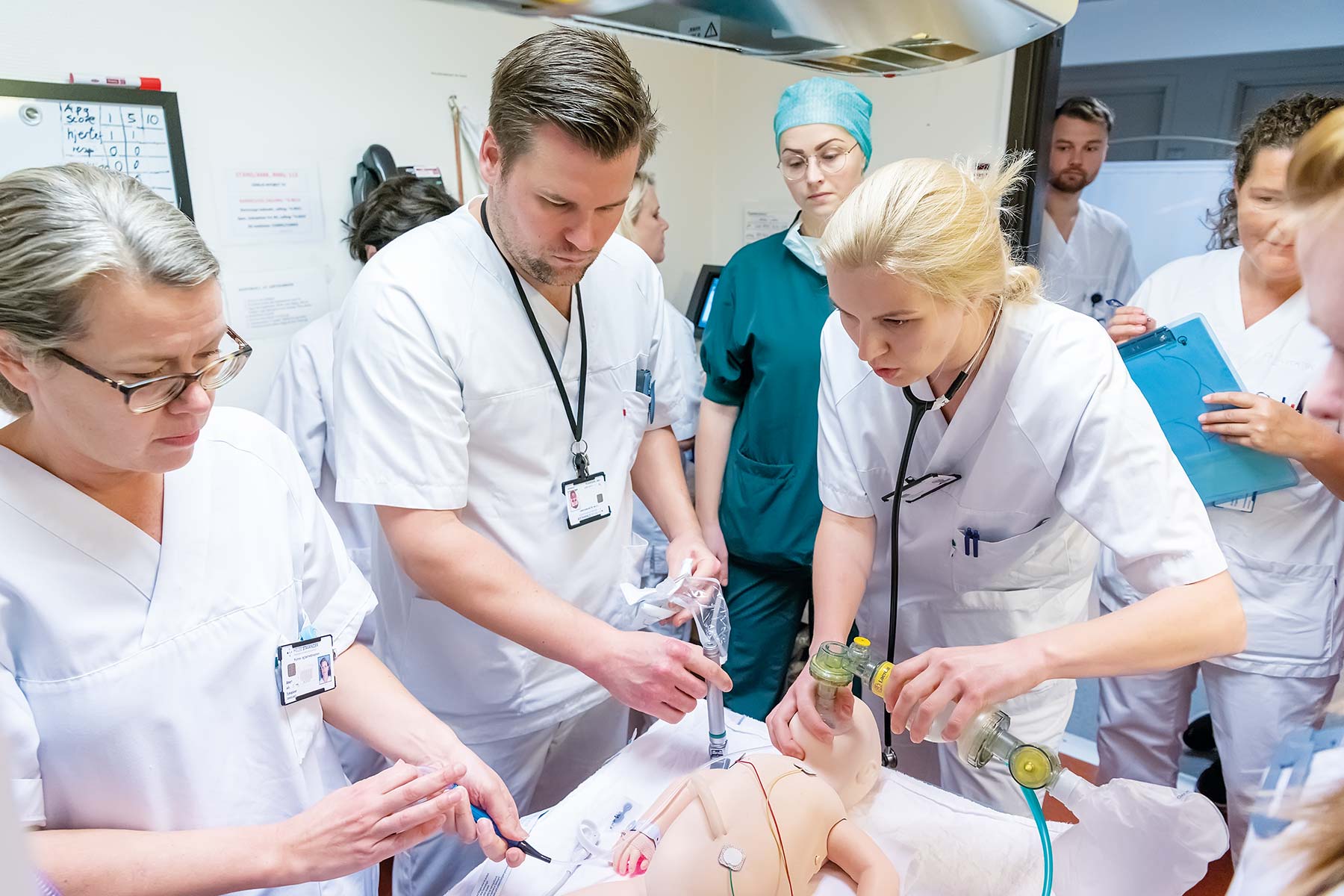 nurses and doctors in a hospital setting training on simbaby manikin