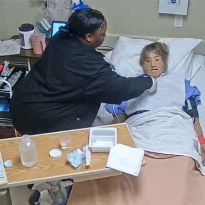 Nurse working on simulation manikin with NAS tray