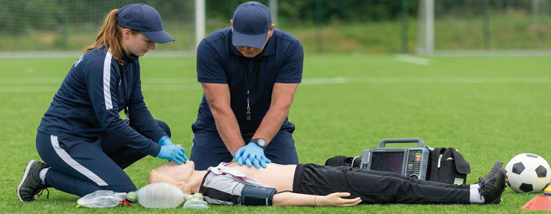 response team performing cpr with a manikin on a soccer field