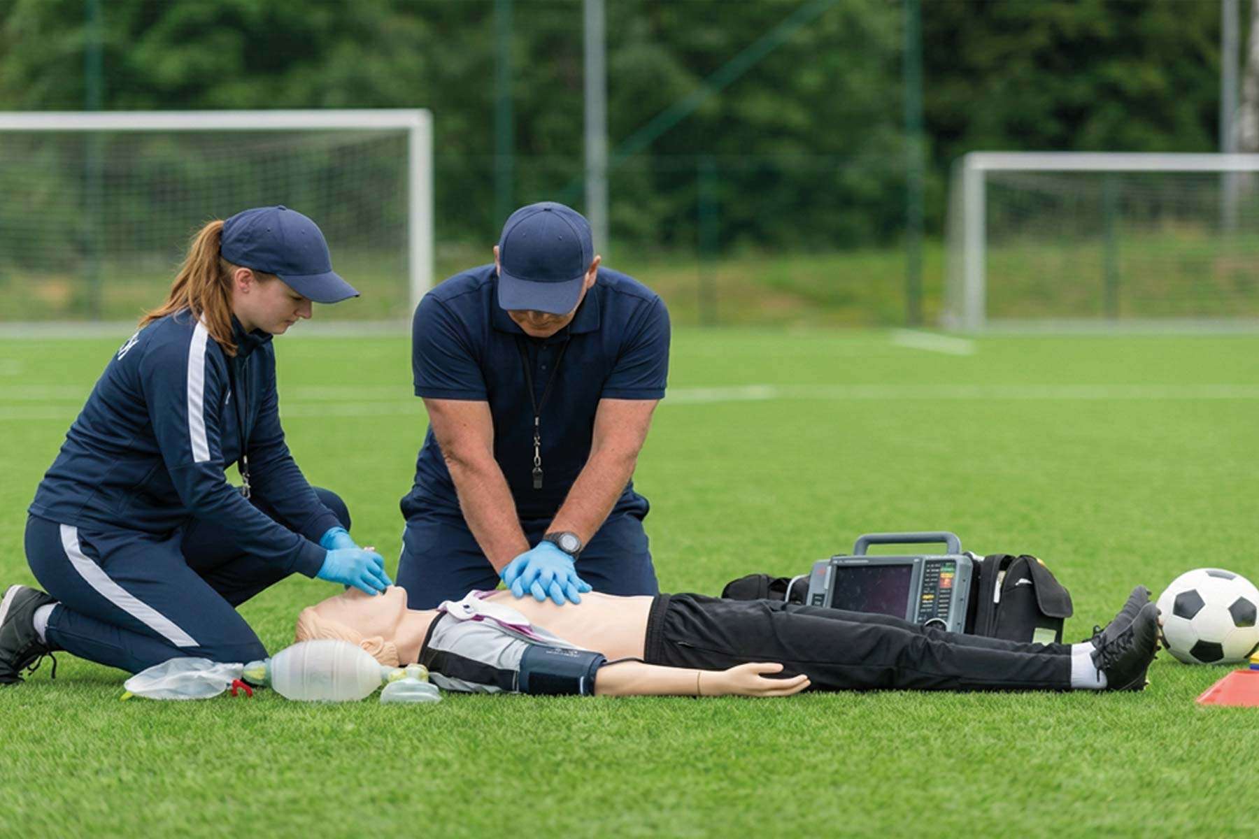 response team performing cpr with a manikin on a soccer field