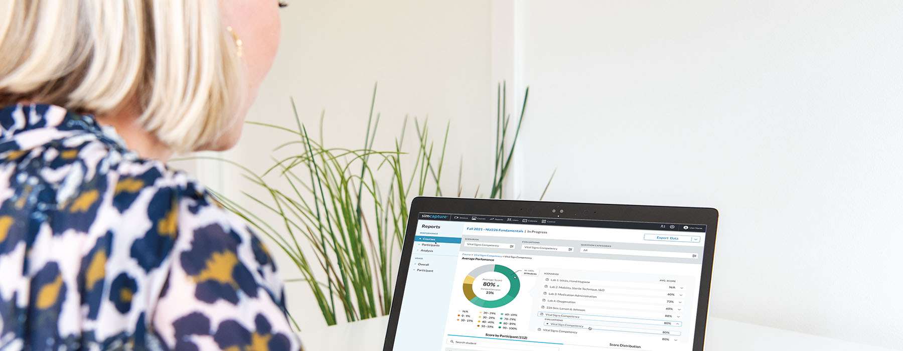 Side view of a woman reviewing stats on a laptop