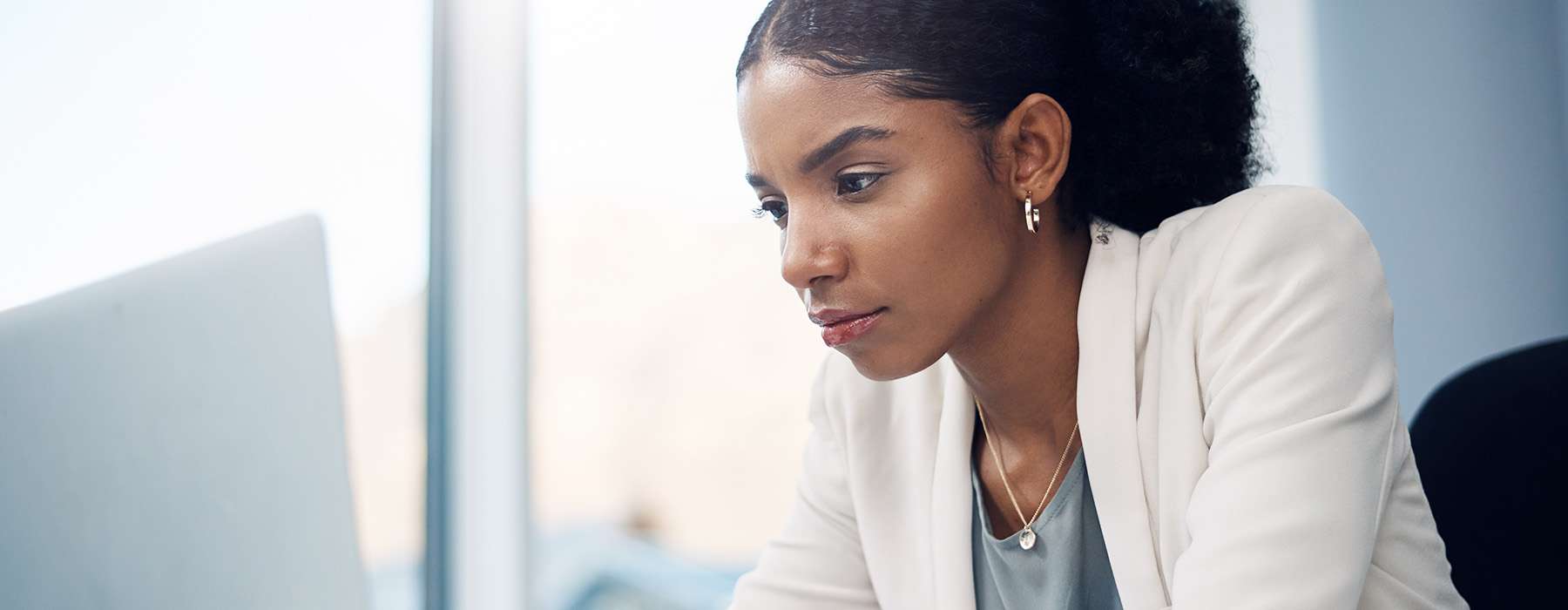 A healthcare professional or educator focused on a laptop screen.