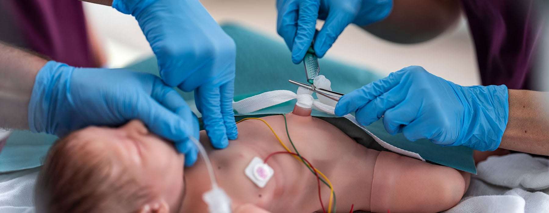 a closeup from NICU. Glowed hands working on a newborn baby.