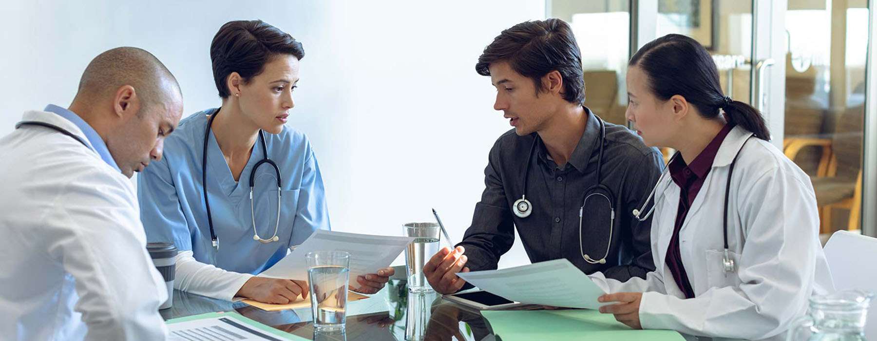 A group of four healthcare professionals in a debrief meeting.