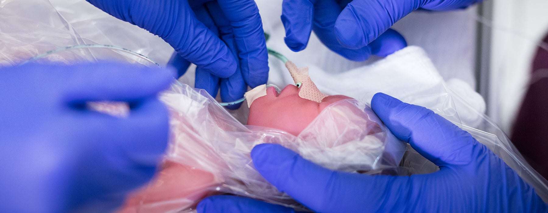 Closeup of simulation training using a baby manikin.