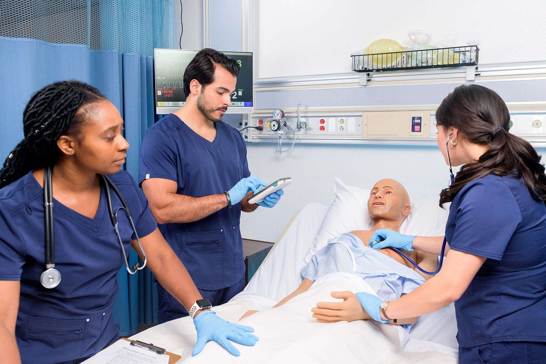 students assessing nursing anne simulator male in a hospital setting