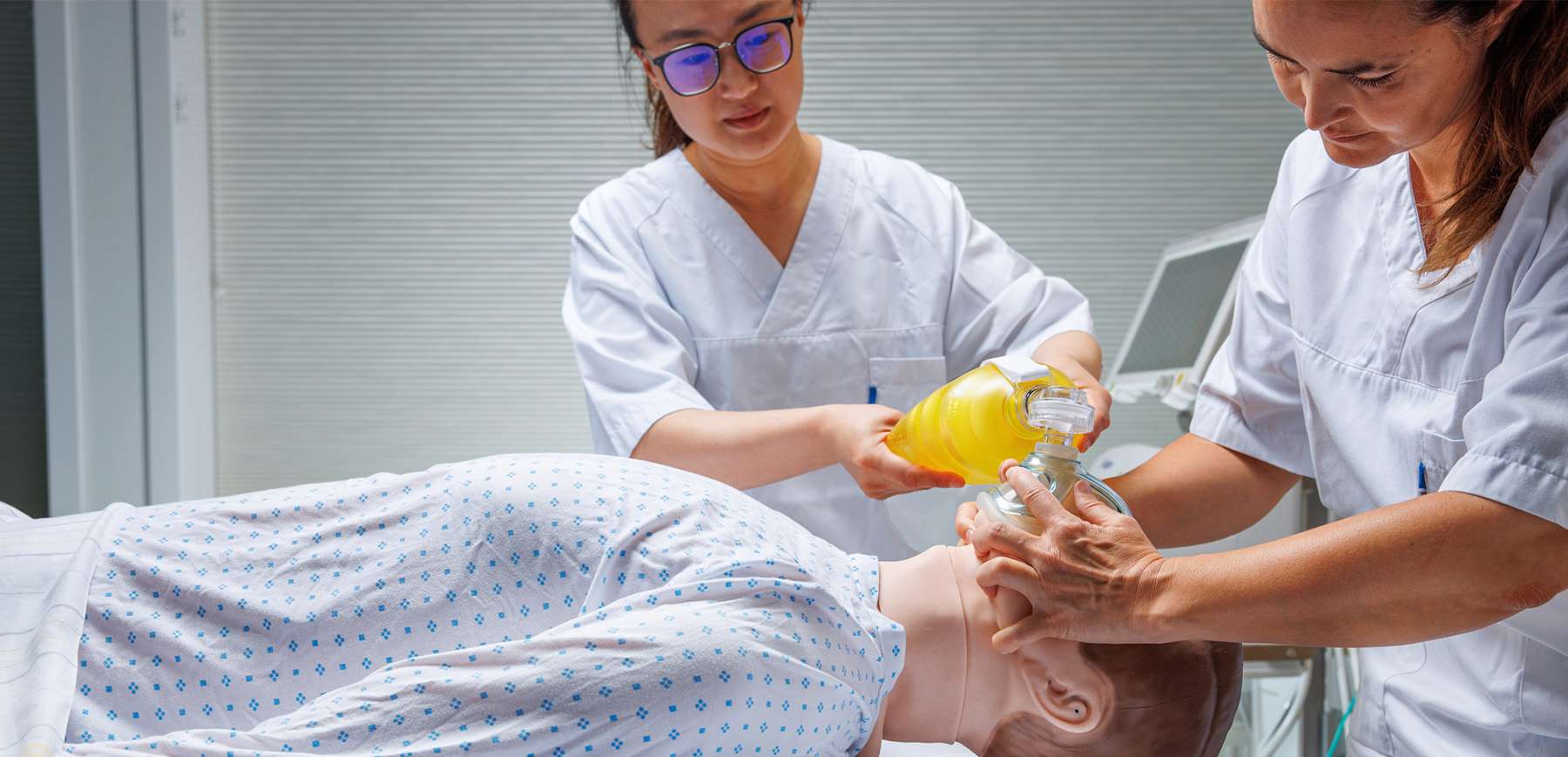 Closeup of two nurses working on SimMan Critical Care.