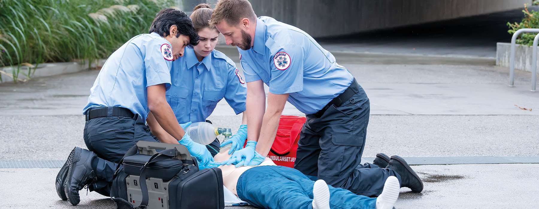 Three EMS operators working on CPR simulation.
