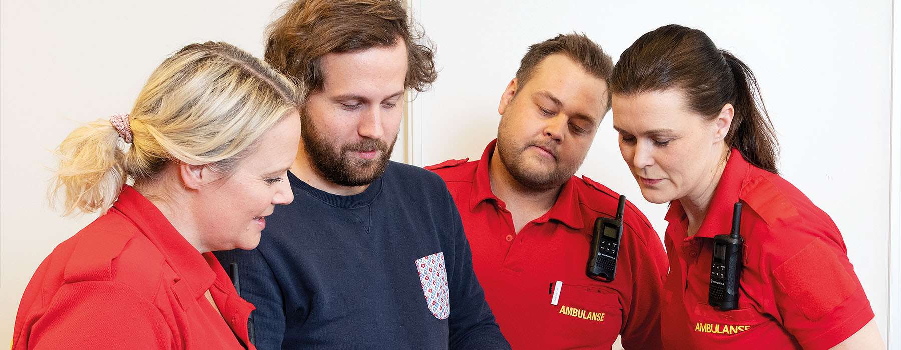 Group of four people looking at tablet.