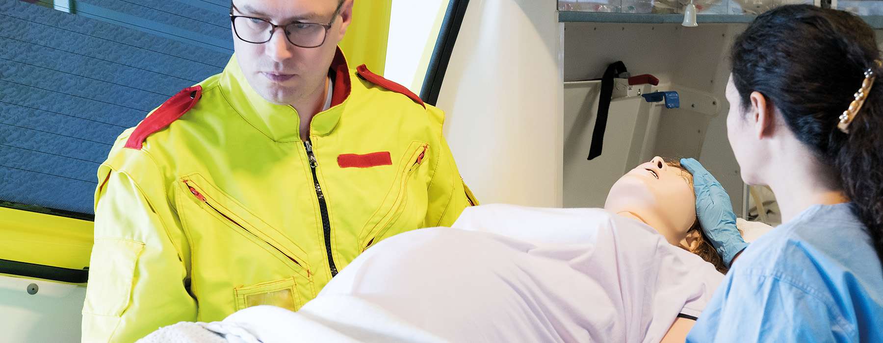 EMS workers in simulation training transporting manikin